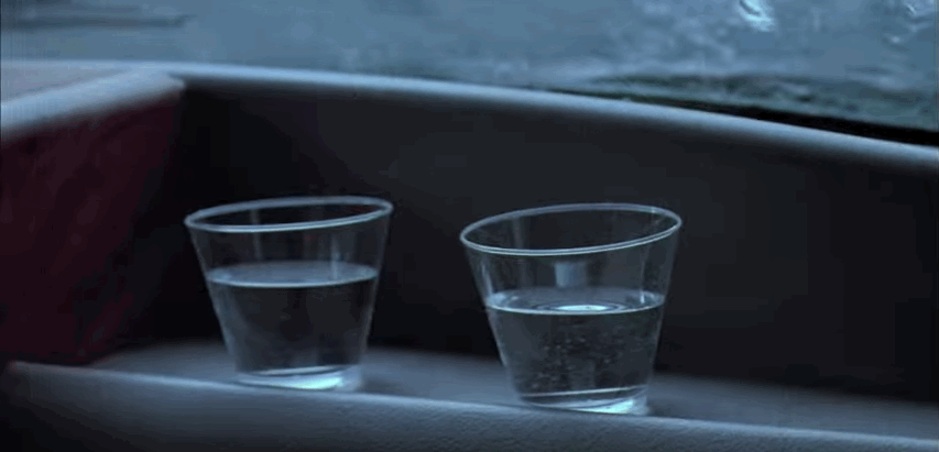 Zooming in on a cup of water that vibrates due to heavy footsteps.