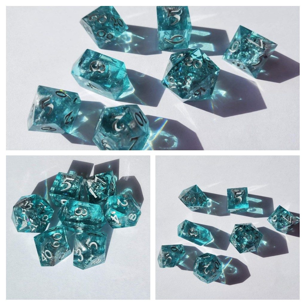 A set of 7 polyhedral dices. They are clear teal with silver numbering and flecks of sliver inside.